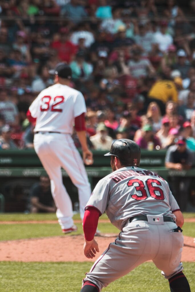 baseball players playing inside the field during daytime